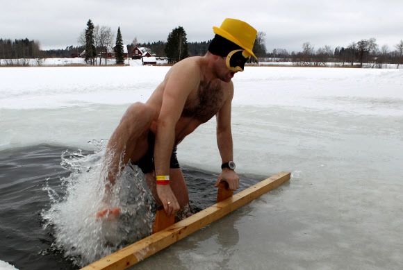 한 남성이 2일(현지시간) 에스토니아 오테파에서 열린 ‘사우나 마라톤’ 중 잠시 차가운 물 속에 몸을 담그고 있다. 참가자들은 오테파 지역의 지정된 사우나를 찾은 후 최대한 빨리 방문해야한다. 최단시간에 모든 사우나를 완료한 팀이 이기게 된다. EPA 연합뉴스