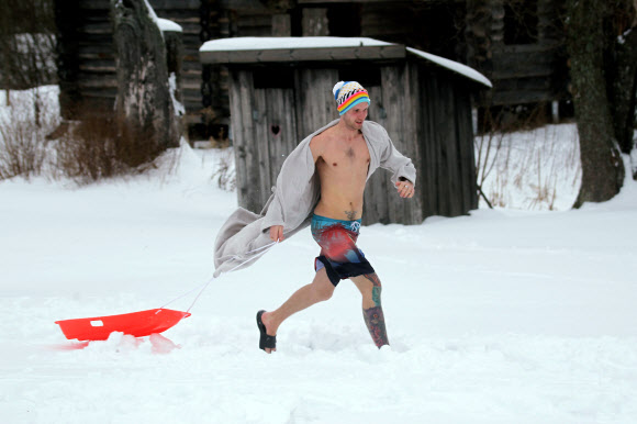 한 남성이 2일(현지시간) 에스토니아 오테파에서 열린 ‘사우나 마라톤’ 중 가운을 입고 달리고 있다. 참가자들은 오테파 지역의 지정된 사우나를 찾은 후 최대한 빨리 방문해야한다. 최단시간에 모든 사우나를 완료한 팀이 이기게 된다. EPA 연합뉴스