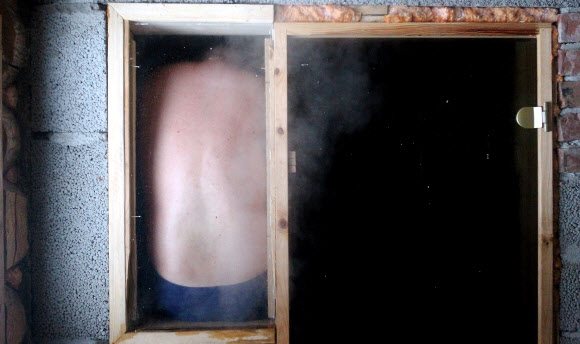 한 남성이 2일(현지시간) 에스토니아 오테파에서 열린 ‘사우나 마라톤’ 중 사우나 안 창가에 앉아 있다. 참가자들은 오테파 지역의 지정된 사우나를 찾은 후 최대한 빨리 방문해야한다. 최단시간에 모든 사우나를 완료한 팀이 이기게 된다. EPA 연합뉴스