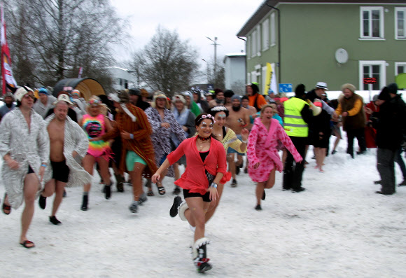 참가자들이 2일(현지시간) 에스토니아 오테파에서 열린 ‘사우나 마라톤’ 중 가운을 입고 달리고 있다. 참가자들은 오테파 지역의 지정된 사우나를 찾은 후 최대한 빨리 방문해야한다. 최단시간에 모든 사우나를 완료한 팀이 이기게 된다. EPA 연합뉴스