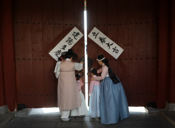 입춘을 맞은 4일 남산 한옥마을에서 입춘첩을 붙인 가족이 대문을 열고 있다. 2019.2.4  연합뉴스