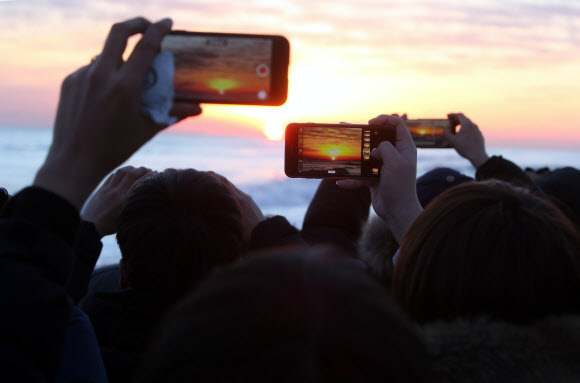 관광객들이 스마트폰으로 사진을 찍고 있다.  연합뉴스 자료사진