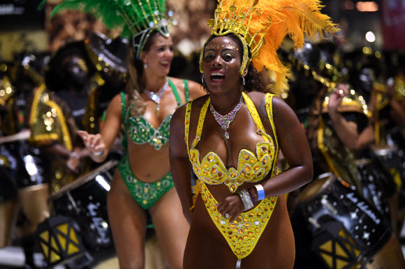 카니발 무용단 ‘콤파르사’ 댄서들이 7일(현지시간) 우루과이의 수도 몬테비데오에서 열린 ‘야마다스 퍼레이드(Llamadas parade)’에서 멋진 몸매를 뽐내며 전통음악 칸돔베(candombe)에 맞춰 춤을 추고 있다. AFP 연합뉴스