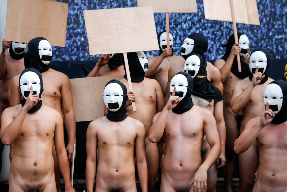 복면을 쓴 사교클럽 회원 남학생들이 8일(현지시간) 필리핀 케손주에 위치한 필리핀 대학교 ‘Oblation Run’ 행사에서 벌거벗은 채 표현의 자유를 외치며 나체 시위를 벌이고 있다. EPA 연합뉴스