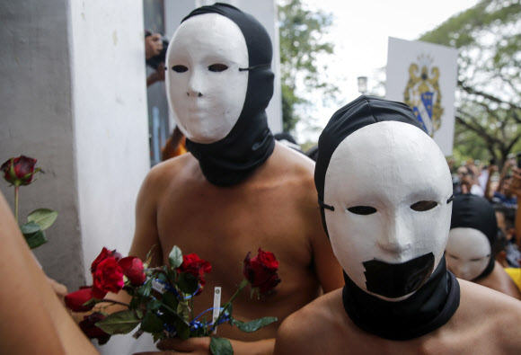 복면을 쓴 사교클럽 회원 남학생들이 8일(현지시간) 필리핀 케손주에 위치한 필리핀 대학교 ‘Oblation Run’ 행사에서 벌거벗은 채 표현의 자유를 외치며 나체 시위를 벌이고 있다. EPA 연합뉴스