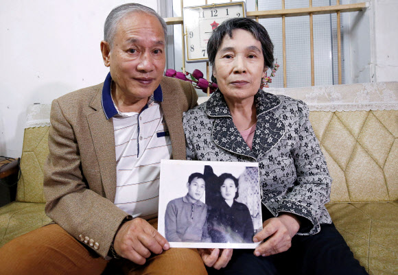 북한 유학생 출신 베트남 남성 팜녹칸(왼쪽)과 북한 여성 이영희씨 부부가 13일 베트남 하노이 자택에서 48년 전인 1971년 촬영한 자신들의 흑백 사진을 들어 보이고 있다.  하노이 로이터 연합뉴스