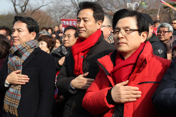 자유한국당 김진태(왼쪽부터), 오세훈, 황교안 당 대표 후보가 16일 오전 경남 창원시 의창구 경남도청 앞에서 열린 ‘댓글조작 김경수 규탄대회’에 참석해 국기에 경례하고 있다. 2019.2.16  연합뉴스