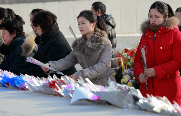 평양 시민들이 16일(현지시간) 김정일 국방위원장의 77돌 생일(광명성절)을 맞아 평양 만수대 김일성·김정일 동상에 꽃을 놓으며 참배하고 있다. AP 연합뉴스