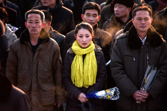 평양 시민들이 16일(현지시간) 김정일 국방위원장의 77돌 생일(광명성절)을 맞아 평양 만수대 김일성·김정일 동상에 꽃을 들고 참배하고 있다. AFP 연합뉴스