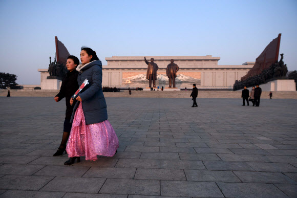 평양 시민들이 16일(현지시간) 김정일 국방위원장의 77돌 생일(광명성절)을 맞아 평양 만수대 김일성·김정일 동상에 꽃을 들고 참배하고 있다. AFP 연합뉴스