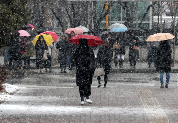 절기상 우수이자 정월대보름인 19일 오전 서울 서초구 강남고속버스터미널 인근에서 시민들이 우산을 쓴 채 신호가 바뀌기를 기다리고 있다. 2019.2.19  연합뉴스
