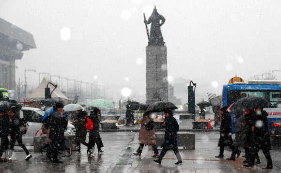 절기상 우수인 19일 오전 서울 세종대로 사거리에서 시민들이 눈을 맞으며 출근하고 있다. 이날 서울 등 중부지방에는 대설주의보가 내려져 낮까지 많은 곳은 최대 10cm 이상 눈이 내릴 것으로 기상청은 예보했다. 2019.2.19  연합뉴스
