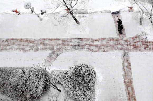 전국 곳곳에 대설특보가 발효 중인 19일 오전 강원 춘천시 사농동의 한 아파트 단지에서 경비원이 눈을 치우고 있다. 2019.2.19  연합뉴스