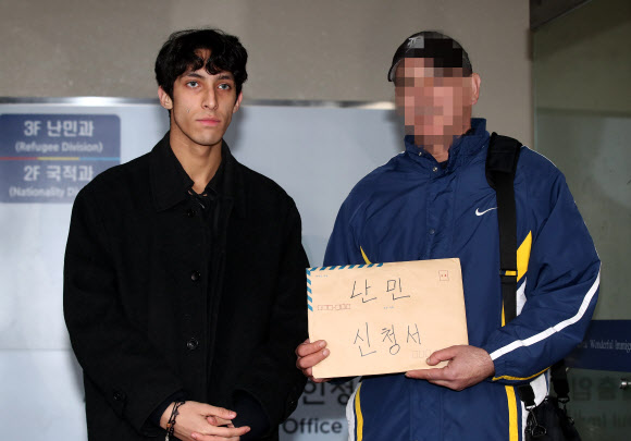 이란 난민 소년 김민혁군이 아버지의 난민 인정 재신청을 위해 19일 오전 서울 양천구 서울출입국외국인청 별관을 방문, 아버지와 난민인정신청서를 들고 있다. 김군의 아버지는 2심까지 행정소송을 진행했으나 패소했다. 2019.2.19  연합뉴스