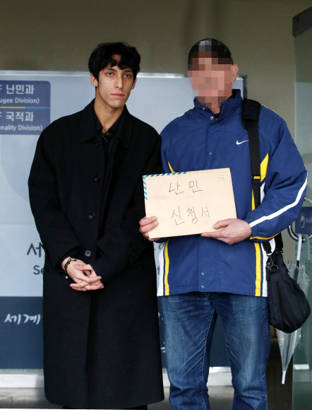 이란 난민 소년 김민혁군이 아버지의 난민 인정 재신청을 위해 19일 오전 서울 양천구 서울출입국외국인청 별관을 방문, 아버지와 난민인정신청서를 들고 있다. 김군의 아버지는 2심까지 행정소송을 진행했으나 패소했다. 2019.2.19  연합뉴스