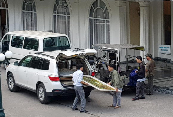 2차 북미정상회담을 여드레 앞둔 19일(현지시간) 베트남 하노이 정부게스트하우스에서 관계자들이 그림을 옮기고 있다. 2019.2.19  연합뉴스