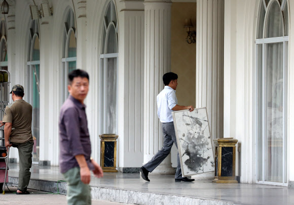 2차 북미정상회담을 여드레 앞둔 19일(현지시간) 베트남 하노이 정부게스트하우스에서 관계자들이 그림을 옮기고 있다. 2019.2.19  연합뉴스