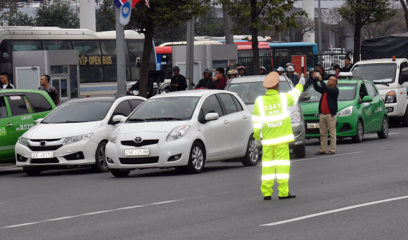 23일 베트남 하노이 노이바이 국제공항 VIP게이트로 미국의 경호장비가 실린것으로 추정되는 차량들이  빠져나가자 경찰이  교통통제를 하고 있다.  2019.2.23 박지환기자 popoca@seoul.co.kr