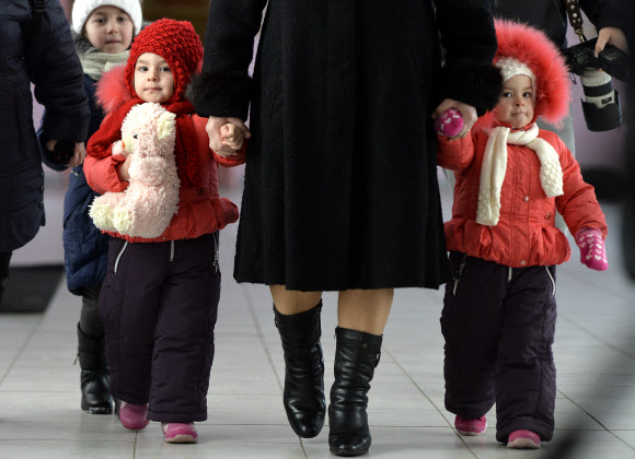 한 여성이 24일(현지시간) 몰도바 키시뇨프에서 2명의 아이들과 함께 투표를 하러 가고 있다. 몰도바인들은 일요일에 친 서구와 친 러시아 세력 간의 분열을 심화시킬 수있는 의회 선거에 투표했다. AP 연합뉴스