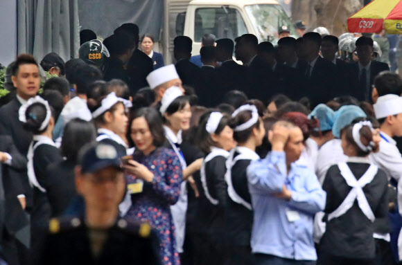 제2차 북미정상회담이 시작된 27일(현지시간) 회담장인 베트남 하노이 메트로폴 호텔로 북측 경호원들이 들어서고 있다. 밖으로 호텔 관계자들이 나와 있다. 2019.2.27  연합뉴스