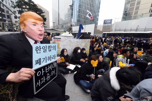 27일  서울 종로구 주한 일본대사관 앞에서 열린  ‘일본군 성노예제 문제 해결을 위한 정기 수요시위’에서 트럼프 마스크를 쓴 한 참가자가 ‘한일합의 폐기하라’가 적힌 손피켓을 들고 있다. 2019.2.27  정연호 기자 tpgod@seoul.co.kr