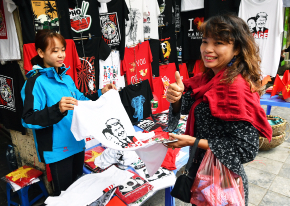 지난 24일 김 위원장과 트럼프 대통령의 얼굴이 그려진 티셔츠를 사는 하노이 시민이 엄지손가락을 치켜들고 있다. 하노이 박지환 기자 popocar@seoul.co.kr