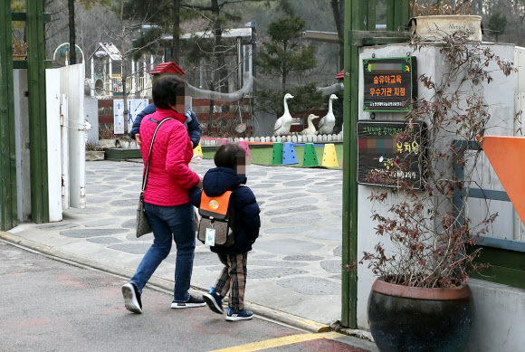 한국유치원총연합회가 개학 연기를 강행한 4일 오전 개학을 연기한 인천시 남동구 한 사립유치원에서 한 학부모가 아동과 함께 등원하고 있다. 이 사립유치원은 이날 개학은 연기했지만 돌봄서비스는 운영하기로 했다. 2019.3.4  연합뉴스