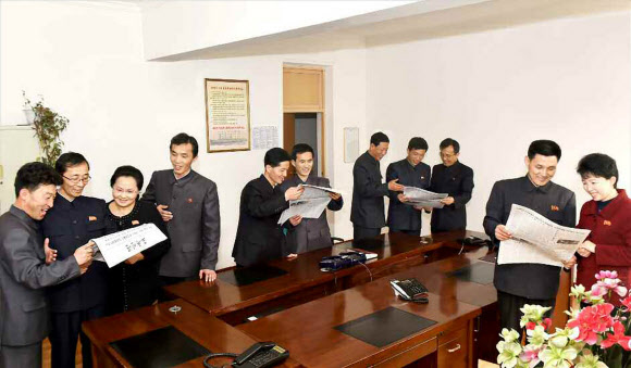 밝은 얼굴로 노동신문 읽는 북한 금속공업성 일꾼들