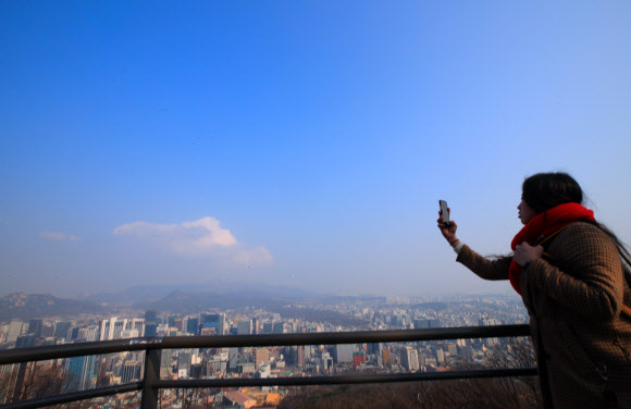 7일 오전 서울 중구 남산에서 한 관광객이 미세먼지가 걷히며 푸른빛을 찾아가는 서울 도심의 모습을 사진으로 담고 있다. 2019.3.7  연합뉴스