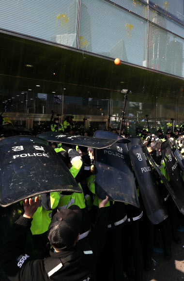 대우조선해양의 매각 본계약 쳬결식이 열린 8일 오후 서울 여의도 산업은행 앞에서 경찰이 금속노조 대우조선지회와 현대중공업지부 노조원들이 던진 계란을 피하기 위해 방패를 들고 있다. 2019.3.8  연합뉴스