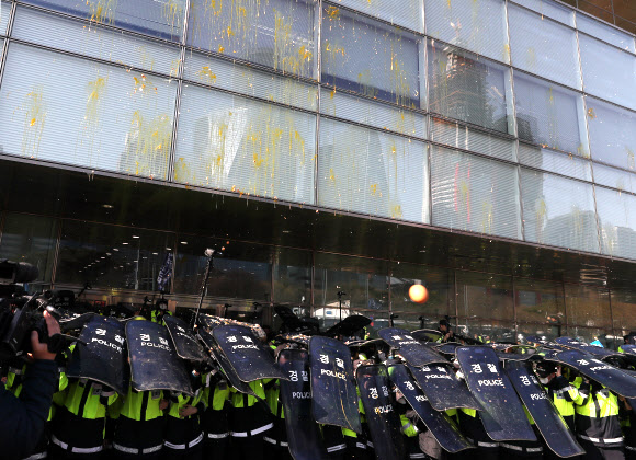 대우조선해양의 매각 본계약 쳬결식이 열린 8일 오후 서울 여의도 산업은행 앞에서 경찰이 금속노조 대우조선지회와 현대중공업지부 노조원들이 던진 계란을 피하기 위해 방패를 들고 있다. 2019.3.8  연합뉴스