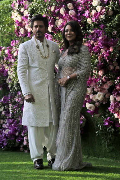 9일 ‘아시아 최고 갑부’ 무케시 암바니 인도 릴라이언스 인더스트리 회장의 장남 아카시 암바니의 결혼식에 참석한 발리우드 배우 커플 샤룩 칸(왼쪽)과 가우리 칸. AP 연합뉴스