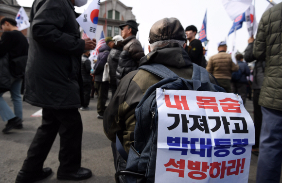 박근혜 전 대통령 탄핵 2년을 맞은 10일 서울역 광장에서 열린 ‘제113차 태극기 집회’에서 박근혜대통령 무죄 석방 1천만 국민운동본부와 대한애국당 등 참석자들이 손팻말과 태극기를 들고 구호를 외치고 있다. 2019. 3. 10. 박윤슬 기자 seul@seoul.co.kr