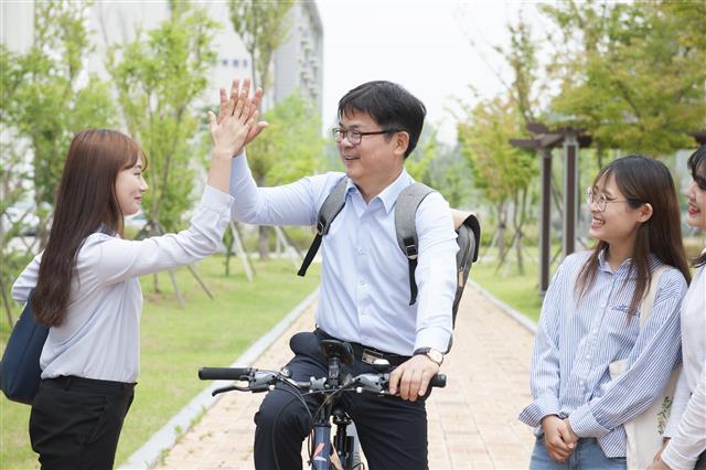 허태웅(오른쪽) 한국농수산대학 총장이 전북 전주 한농대 캠퍼스에서 출근길에 만난 학생과 손뼉을 마주치고 있다.  한농대 제공