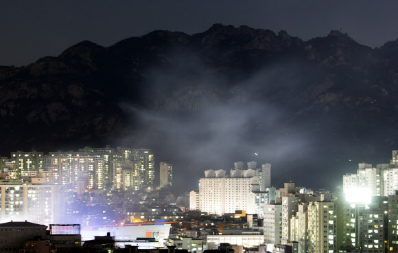 13일 서울 은평구 모델하우스 화재의 불씨가 옮겨붙은 북한산 일대에서 야간 화재 진압작업이 진행되고 있다. 2019.3.13 연합뉴스