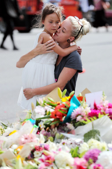 16일 (현지시간) 뉴질랜드 크라이스트처치의 이슬람 사원에서 발생한 총격 테러 인근 주민들이 희생자들을 위해 헌화하며 추모하고 있다. AFP 연합뉴스