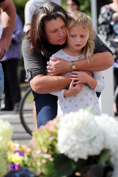 16일 (현지시간) 뉴질랜드 크라이스트처치의 이슬람 사원에서 발생한 총격 테러 인근 주민들이 희생자들을 위해 헌화하며 추모하고 있다. AFP 연합뉴스