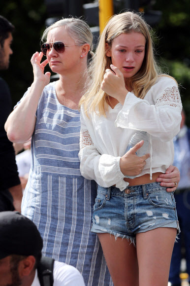 16일 (현지시간) 뉴질랜드 크라이스트처치의 이슬람 사원에서 발생한 총격 테러 인근 주민들이 희생자들을 위해 헌화하며 눈물을 흘리고 있다. AFP 연합뉴스