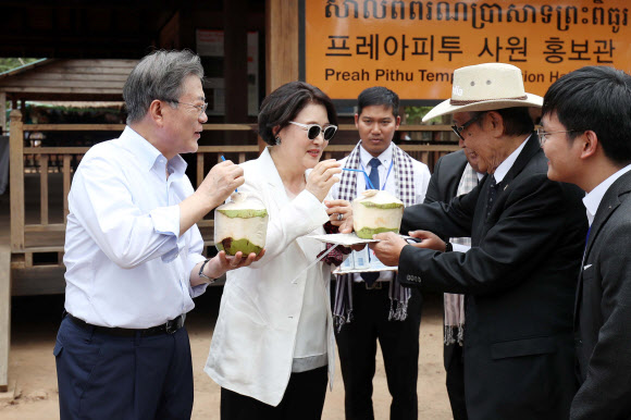 문재인 대통령과 김정숙 여사가 16일 오후(현지시간) 캄보디아 시엠립 프레아피투 사원을 둘러본 후 콩솜올 부총리 겸 왕실부장관이 준 야자열매 음료를 맛보고 있다. 2019.3.16  연합뉴스