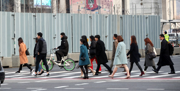 19일 오전 서울 광화문광장에서 출근길 시민들이 세월호 분향소가 있던 자리 앞을 지나가고 있다. 분향소와 천막이 철거된 곳에는 기존 천막의 절반 규모로 ‘기억·안전 전시공간’이 조성된다. 2019.3.19  연합뉴스