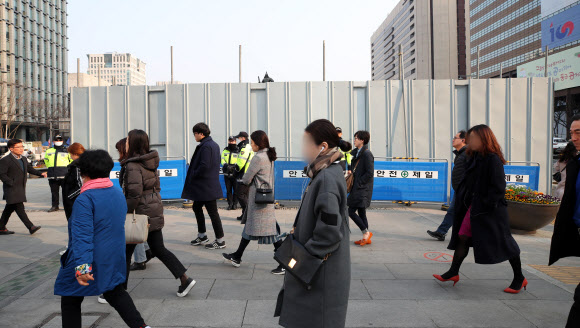 19일 오전 서울 광화문광장에서 출근길 시민들이 세월호 분향소가 있던 자리 앞을 지나가고 있다. 분향소와 천막이 철거된 곳에는 기존 천막의 절반 규모로 ‘기억·안전 전시공간’이 조성된다. 2019.3.19  연합뉴스