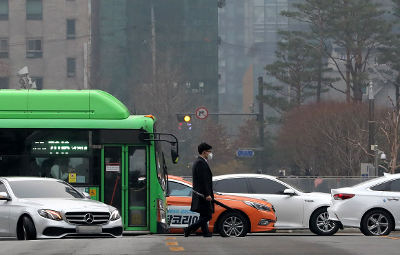 초미세먼지 주의보가 발령된 20일 오전 서울 광화문 세종문화회관 인근에서 마스크를 착용한 시민이 출근길을 재촉하고 있다. 2019.3.20  연합뉴스