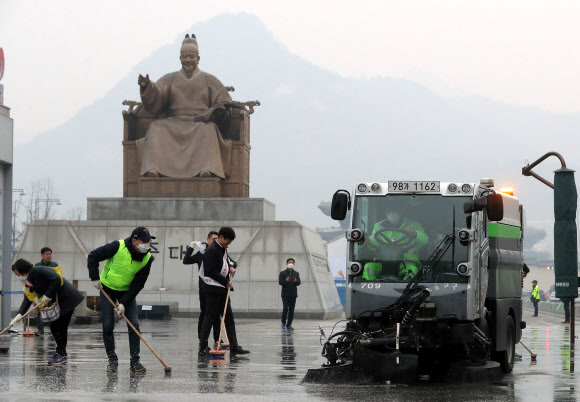 초미세먼지 주의보가 발령된 20일 오전 서울 광화문광장에서 서울시·종로구 직원들과 시민들이 미세먼지 제거 물청소를 하고 있다. 2019.3.20  연합뉴스