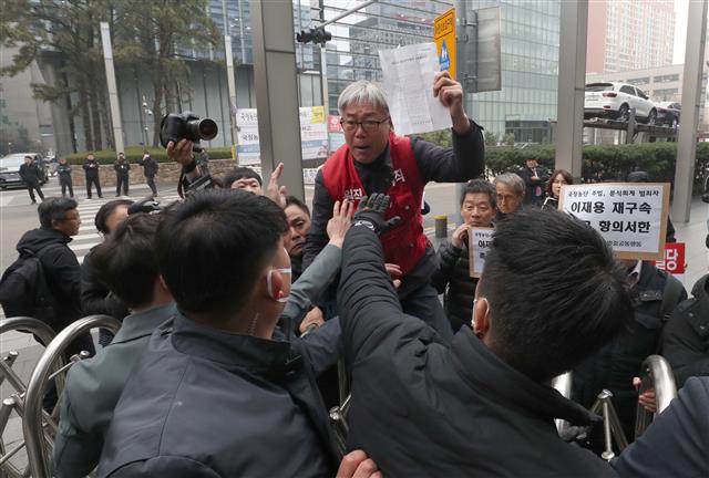 민주노총 조합원, 삼성 해고노동자 등이 20일 오전 서울 서초구 삼성전자 사옥 앞에서 ‘국정농단 주범 이재용 재구속 촉구, 경영권 박탈 투쟁선포 기자회견’을 마친 후 주주총회 참석을 요구하고 있다. 2019.3.20 뉴스1