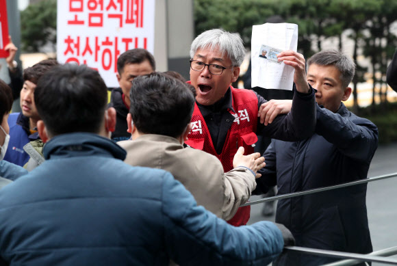 민주노총 조합원과 삼성 해고노동자 등이 20일 오전 서울 서초동 삼성사옥 앞에서 ‘국정농단 주범 이재용 재구속 촉구, 경영권 박탈 투쟁선포 기자회견’을 마치고 주주총회 참석을 요구하고 있다. 2019.3.20  연합뉴스