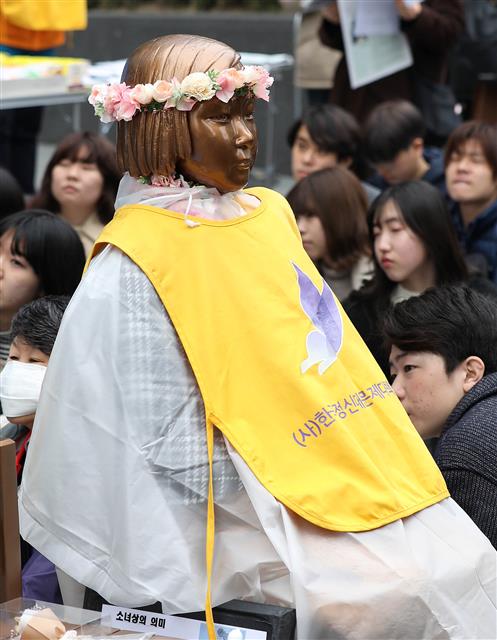 20일 서울 종로구 옛 일본대사관 앞에서 열린 제1379차 일본군성노예제 문제해결을 위한 정기 수요시위가 봄을 맞이해 화관을 쓴 평화의 소녀상과 함께 열리고 있다. 2019.3.20 뉴스1
