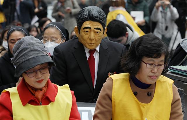 20일 서울 종로구 옛 일본대사관 앞에서 열린 제1379차 일본군성노예제 문제해결을 위한 정기 수요시위에 한 참가자가 아베 신조 일본 총리의 가면을 쓰고 고개를 숙이고 있다. 2019.3.20 뉴스1