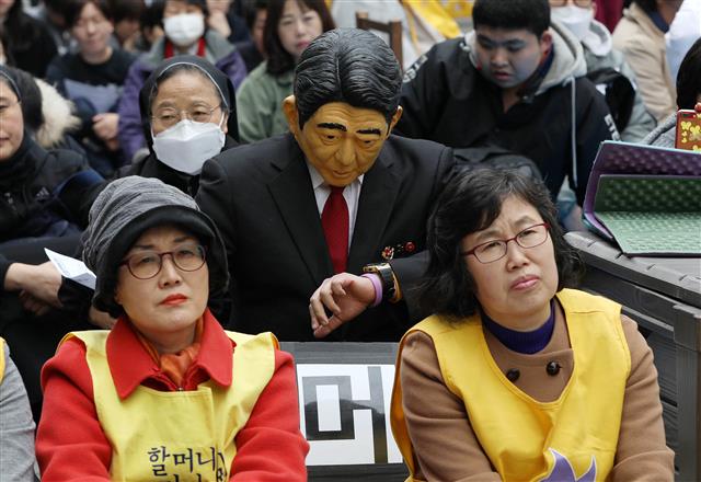 20일 서울 종로구 옛 일본대사관 앞에서 열린 제1379차 일본군성노예제 문제해결을 위한 정기 수요시위에 한 참가자가 아베 신조 일본 총리의 가면을 쓰고 참가해 시계를 바라보고 있다. 2019.3.20 뉴스1