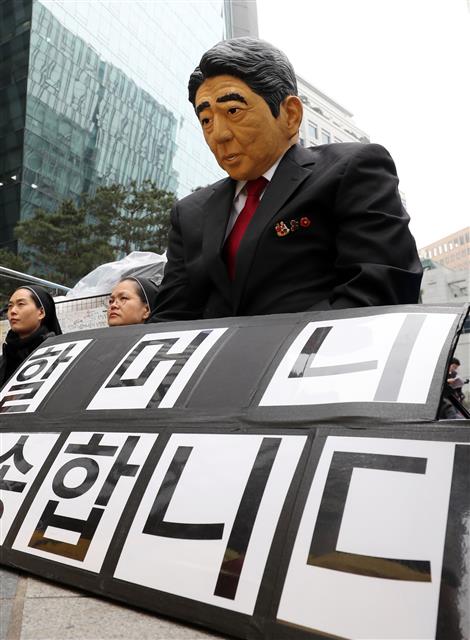 20일 서울 종로구 옛 일본대사관 앞에서 열린 제1379차 일본군성노예제 문제해결을 위한 정기 수요시위에서 한 참가자가 아베 신조 일본 총리의 가면을 쓰고 ‘할머니 죄송합니다’ 팻말과 함께 고개를 숙이고 있다. 2019.3.20 뉴스1