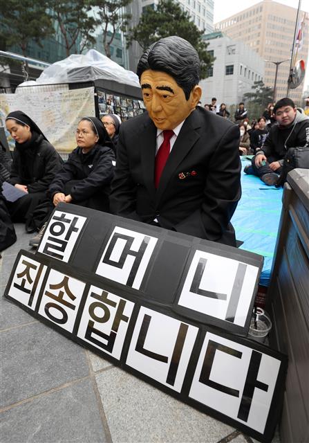 20일 서울 종로구 옛 일본대사관 앞에서 열린 제1379차 일본군성노예제 문제해결을 위한 정기 수요시위에서 한 참가자가 아베 신조 일본 총리의 가면을 쓰고 ‘할머니 죄송합니다’ 팻말과 함께 고개를 숙이고 있다. 2019.3.20 뉴스1